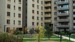 Contemporary high-rise apartment buildings with lush greenery and pathways in the courtyard.